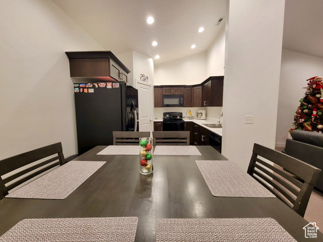 Dining space featuring sink and high vaulted ceiling