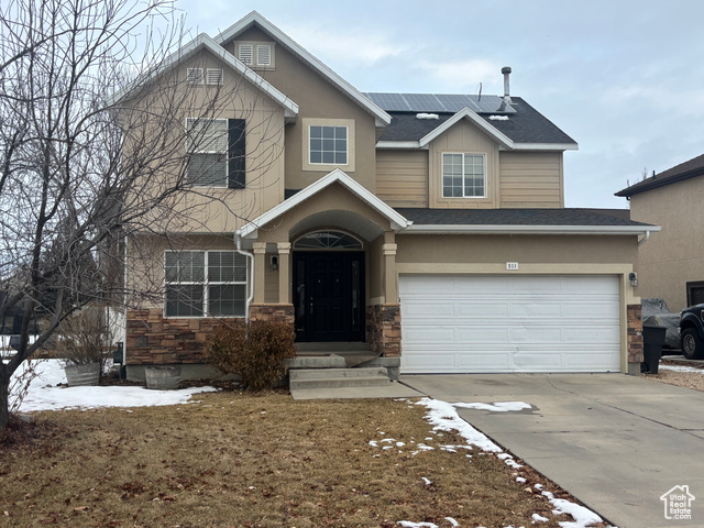 Craftsman-style home featuring solar panels and a garage