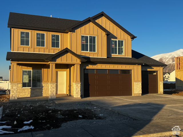 View of front of property with a garage and a mountain view