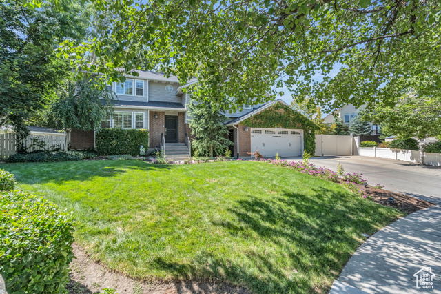 Front of property featuring a front lawn and a garage