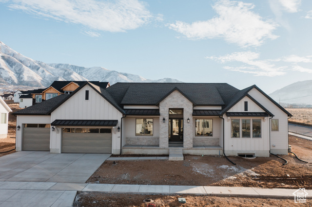 View of front of home with a mountain view, a porch, and a garage