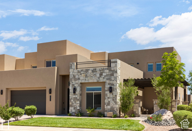 Pueblo-style home featuring a garage