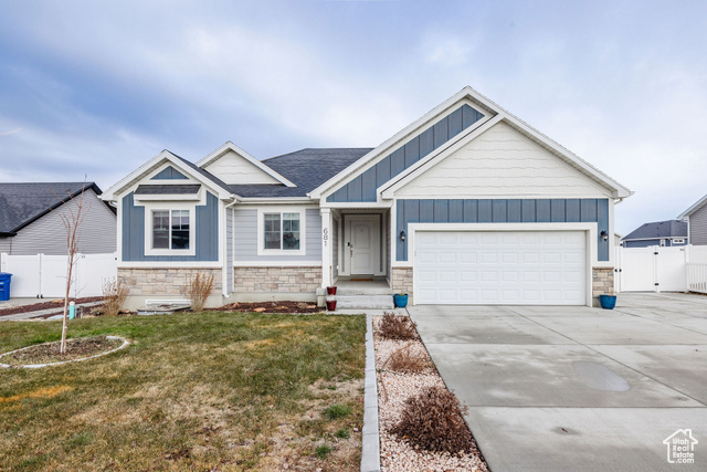 Craftsman house featuring a front lawn and a garage