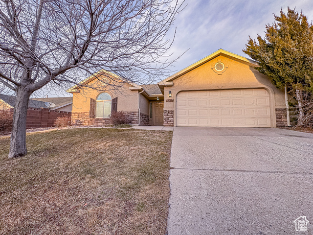 View of front facade featuring a front yard and a garage