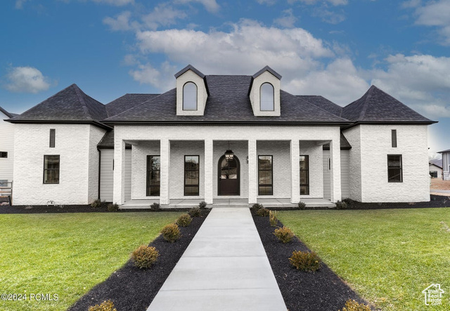 French country style house with a porch and a front lawn