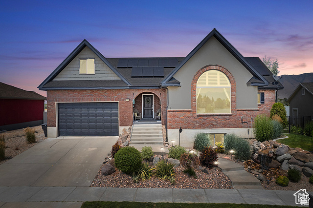 View of front facade with solar panels and a garage