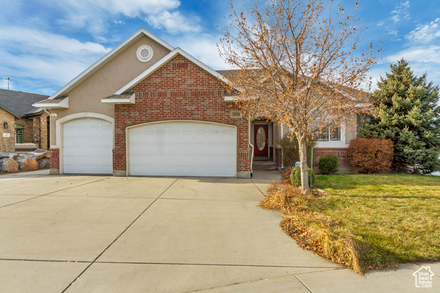 View of front of property featuring a front yard and a garage