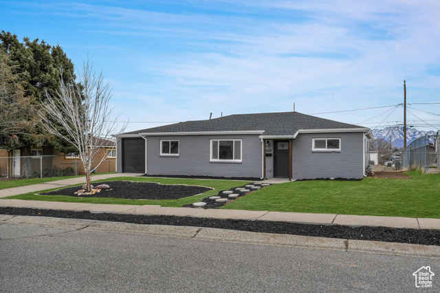 Ranch-style home featuring a front lawn