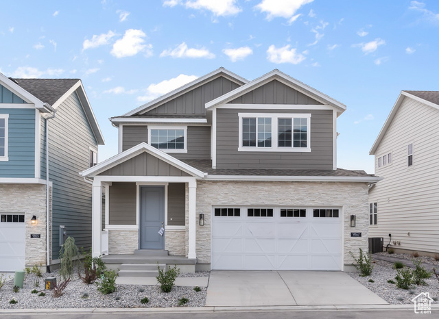 Craftsman inspired home with a garage and central air condition unit