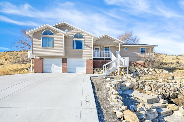 View of front of home with a porch and a garage