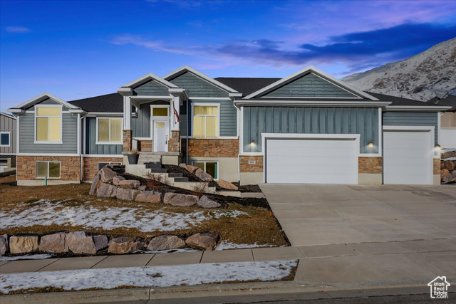 View of front of house with a mountain view and a garage