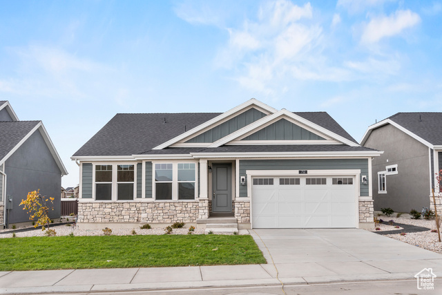 Craftsman house with a front lawn and a garage