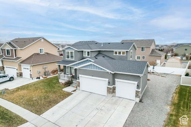 View of front of home with a porch, a garage, and a front yard