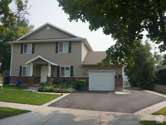 View of front of home with a garage and front lawn