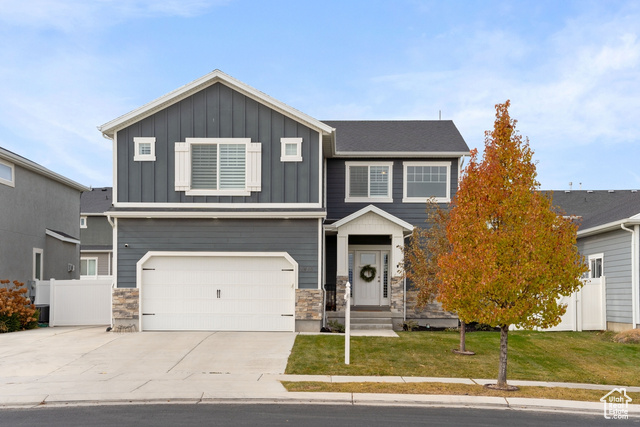 View of front of home with a garage and a front lawn