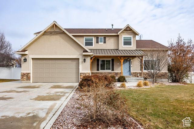 View of front of home with a garage and a front yard