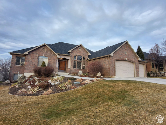 View of front of home with a front yard and a garage