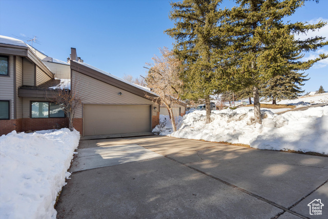 Snow covered property with a garage