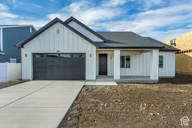 Modern inspired farmhouse featuring a porch and a garage