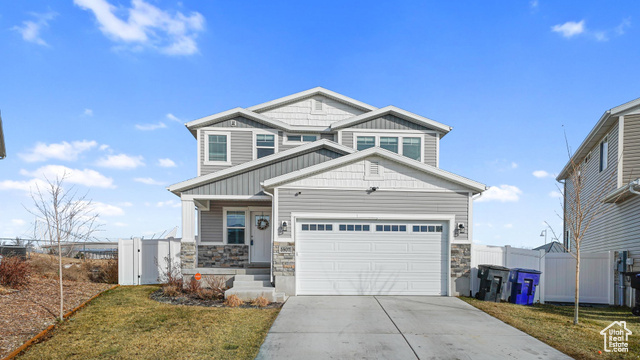 Craftsman inspired home featuring a front yard and a garage