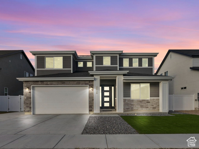 View of front of house with a yard and a garage