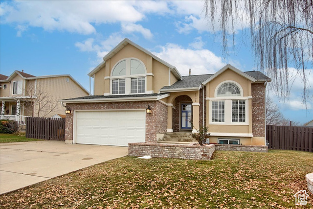 View of front facade featuring a front yard and a garage