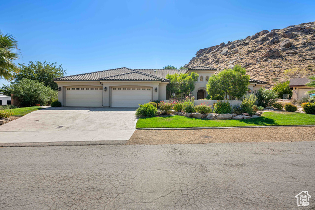 Mediterranean / spanish home featuring a mountain view, a front yard, and a garage