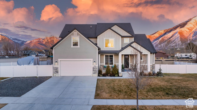 View of front of home featuring a lawn, a mountain view, and a garage