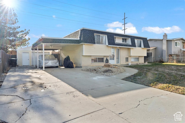 View of front facade featuring a carport and one car garage/workshop