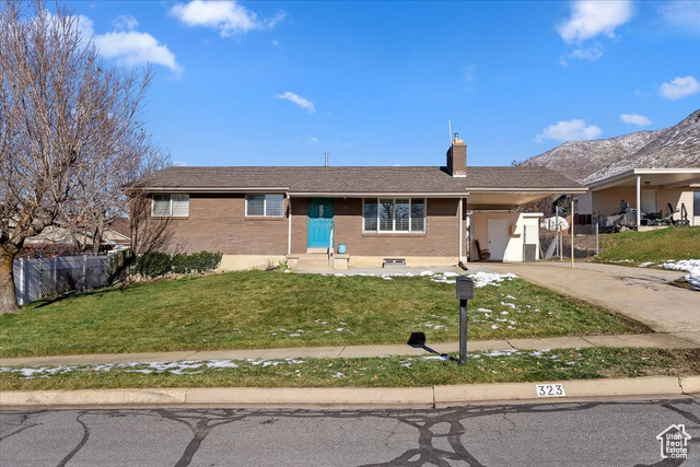 Ranch-style home with a front yard and a carport