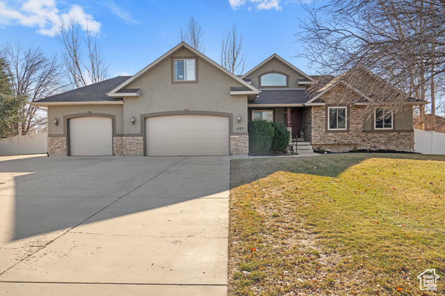 View of front of house featuring a front yard, additional parking, RV parking, and 3 car garage