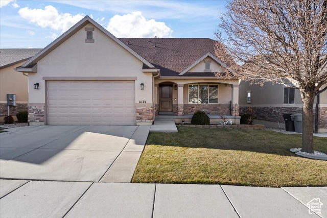 View of front of property with a front yard and a garage