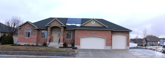 View of front facade with solar panels and a garage