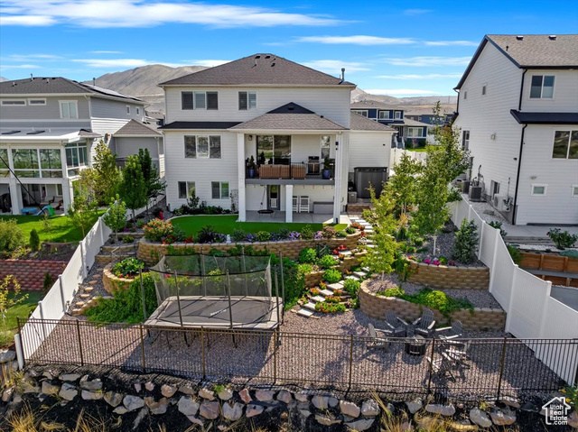 Back of property with a mountain view, covered porch and deck with high end landscaping