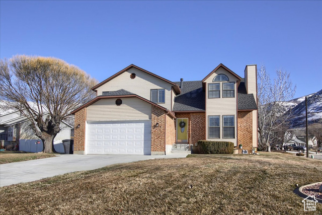 View of property featuring a garage and a front yard