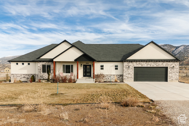 Craftsman inspired home featuring a mountain view, a garage, and a front lawn