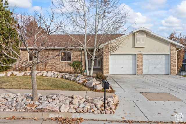 Ranch-style home featuring a garage and a front yard