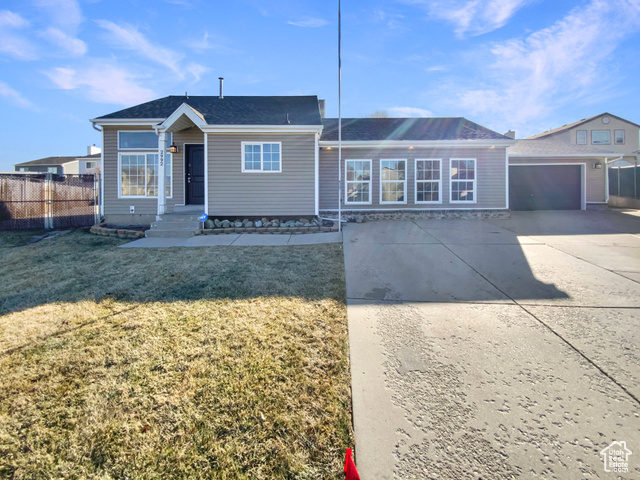 Single story home with a garage and a front yard