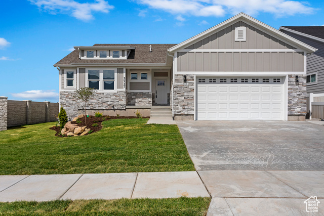 View of front of house with a garage and a front lawn