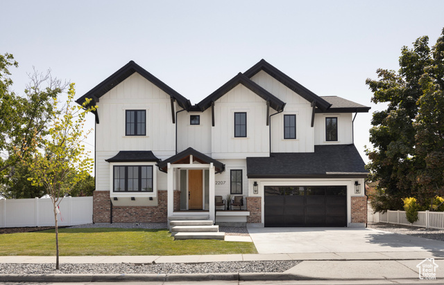 Modern inspired farmhouse with a front yard and a garage