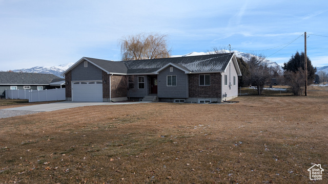 View of front of home featuring a mountain view, a garage, and a front yard