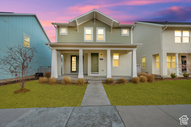 View of front facade with a yard and a porch