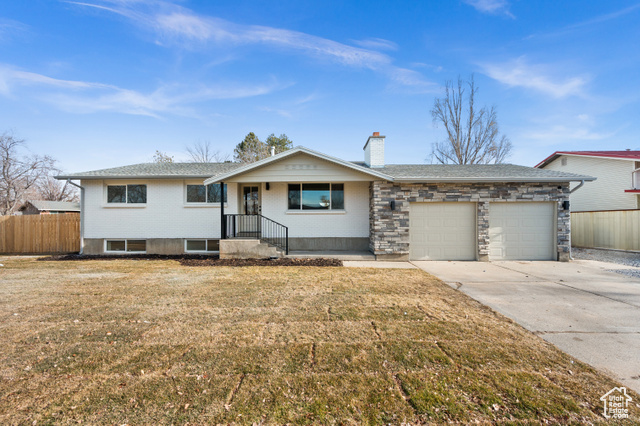 Ranch-style house featuring a garage and a front yard