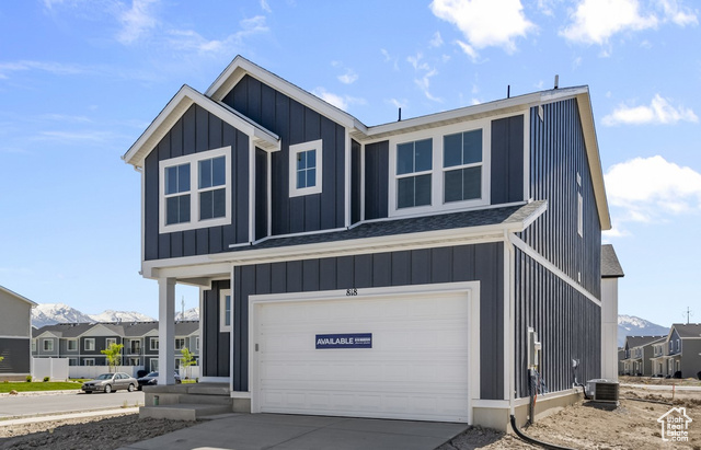 View of front of property with central AC unit and a garage