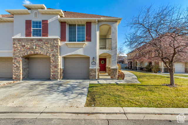 View of front of property featuring a garage and a front yard