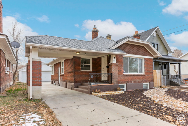 View of front of house with covered porch, a garage, and an outdoor structure