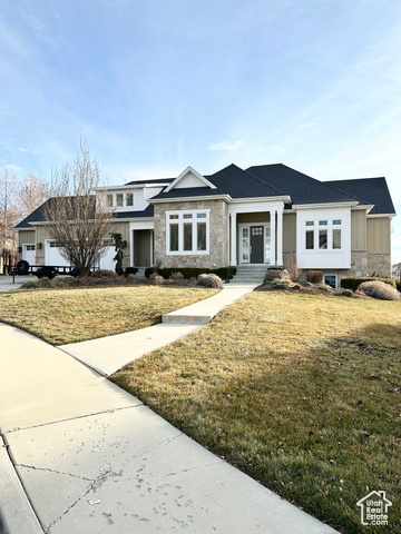 View of front of home with a front yard and a garage