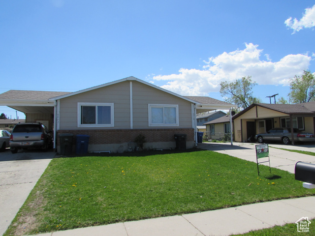 Ranch-style house with a front lawn and a carport