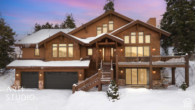 View of front facade with a deck and a garage