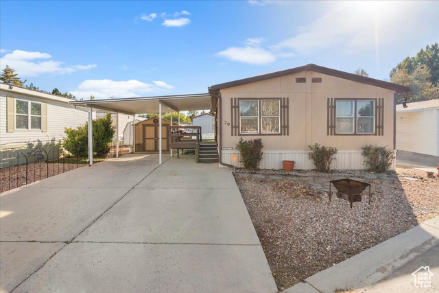 Manufactured / mobile home with a storage unit, a deck, and a carport